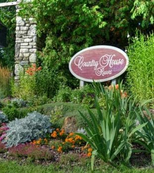 Frequently Asked Questions and Country House entry sign in summer