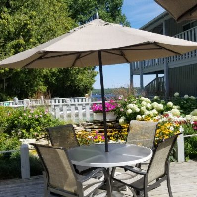 Pool deck with table surrounded by a flower garden